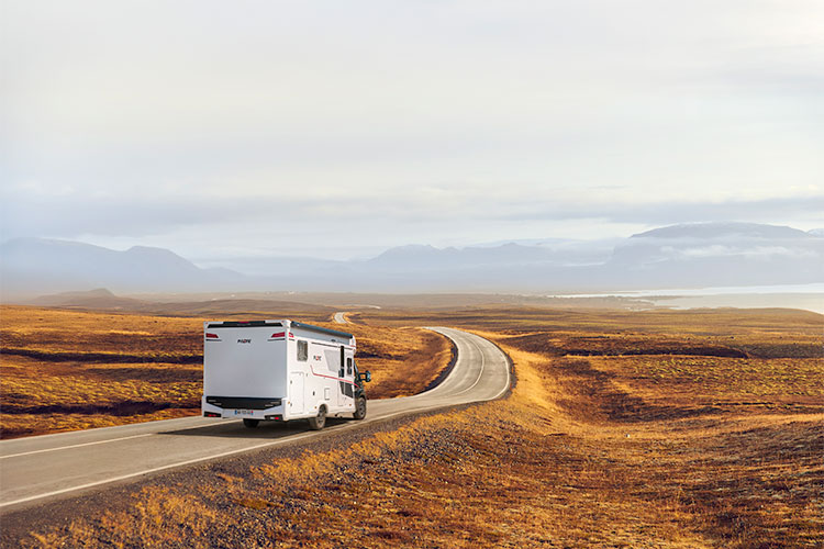 camping-car profilé compact Pilote roulant sur une route dans des steppes