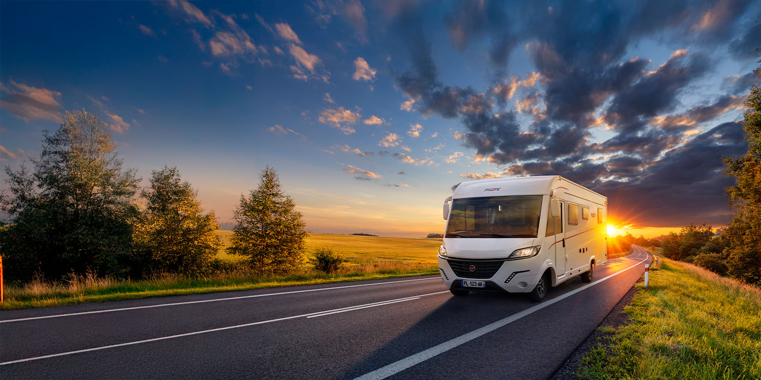 camping-car intégral Pilote roulant sur une route au coucher de soleil