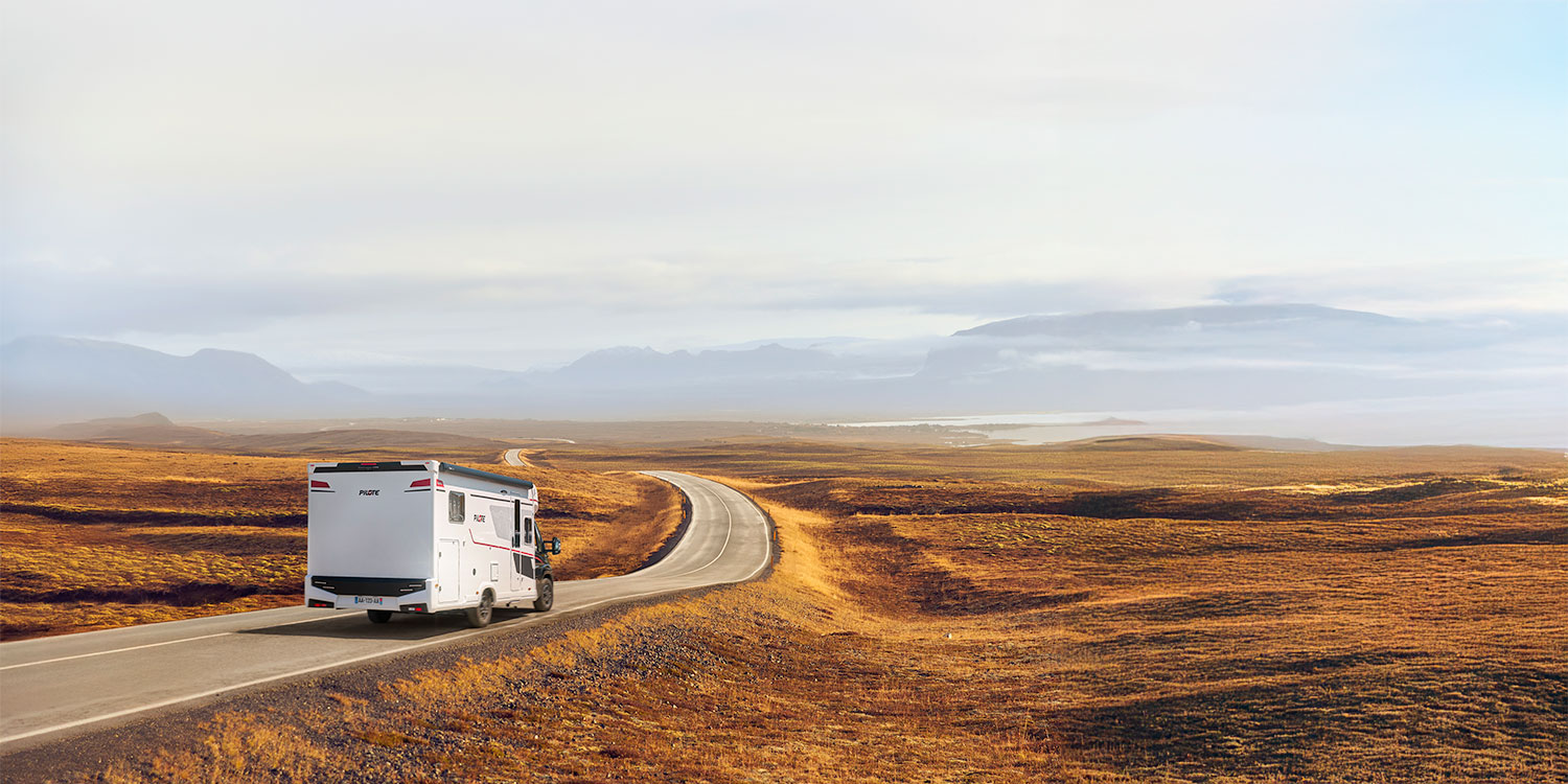 camping-car profilé compact Pilote roulant sur une route dans des steppes