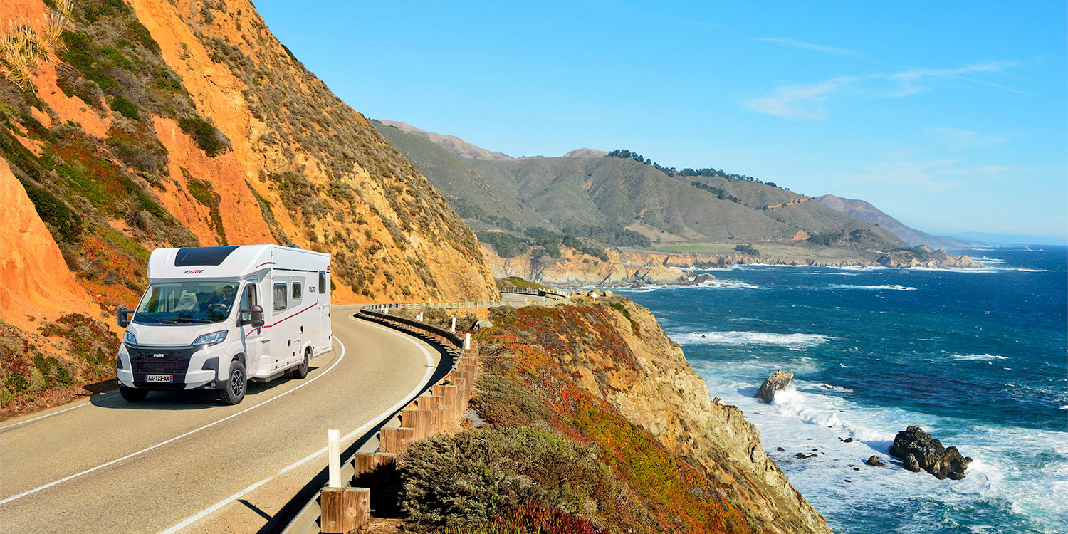 camping-car profilé Pilote roulant sur une route de bord de mer