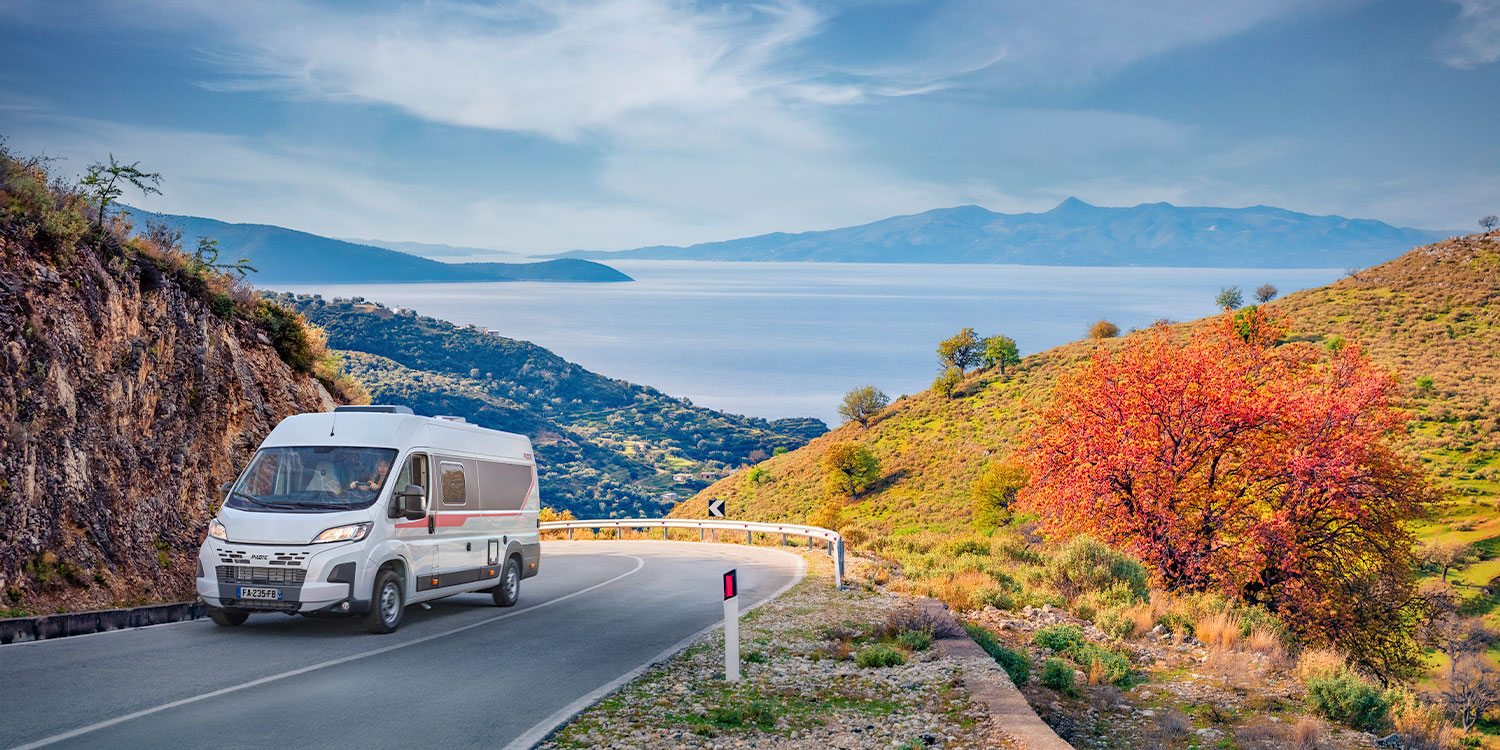 fourgon aménagé Pilote roulant sur une route de montagne
