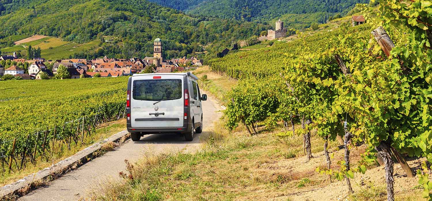 Van aménagé Pilote se dirigeant vers un petit village 